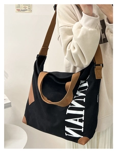 Détail du sac fourre-tout en toile noire avec lettrage MAIMI et base renforcée brune