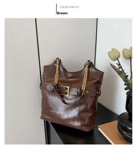 Détail du sac cabas marron avec boucle dorée et bandoulière en chaîne pour le travail