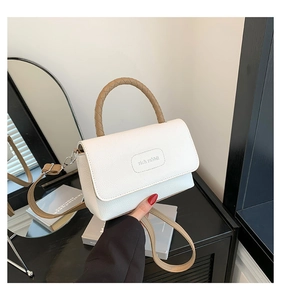 Détail du sac en cuir blanc avec poignée tressée marron et logo rich rabbit gravé