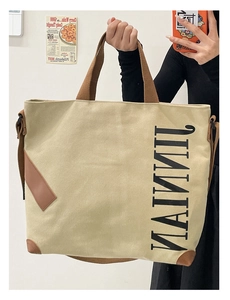 Détail du grand sac cabas en toile avec poignées marron et coins en cuir renforcés