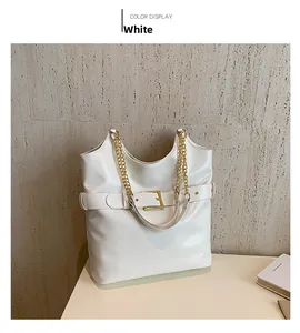 Détail du sac cabas blanc brillant avec bandoulière chaîne dorée et boucle décorative