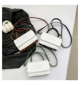 Détails de trois sacs carrés minimalistes en similicuir texturé marron, noir et vert