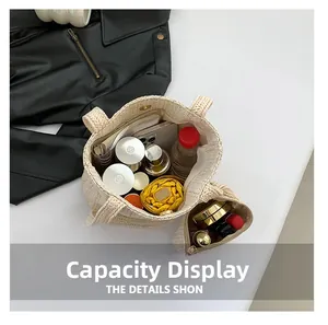 Intérieur d'un grand sac cabas beige tressé montrant sa capacité pour parapluie et accessoires