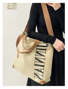 Détail du sac cabas en toile avec poignées en cuir marron et texte MAIMUI