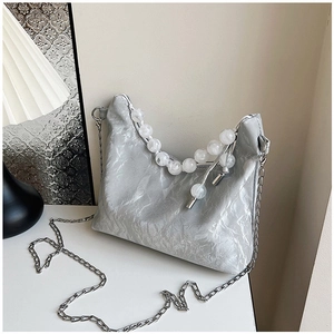 Detail of silver pleated hobo bag with white marble beads handle and metal chain strap