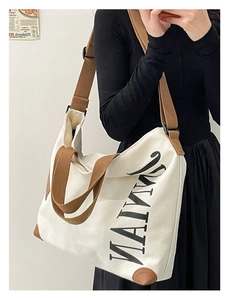 Sac fourre-tout en toile beige avec anses marron montré dans un selfie miroir