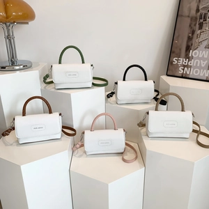 Sac à main minimaliste en cuir blanc avec poignées colorées sur présentoir