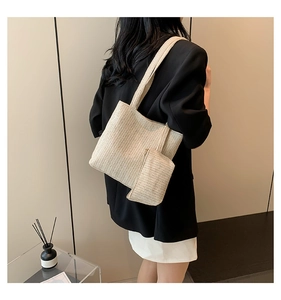 Détail du sac cabas en paille tressée avec pochette assortie dans un cadre minimaliste
