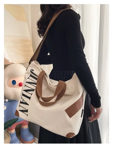 Détail du grand sac cabas en toile avec imprimé JINNIAN et bandoulière en sangle brune
