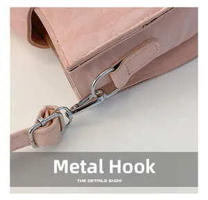 Nahaufnahme des silbernen Metallhakens an der rosa Kunstleder-Schultertasche