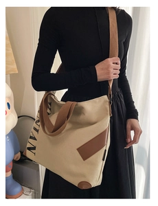 Détail du fourre-tout en toile avec renfort de base en cuir brun et imprimé de lettres