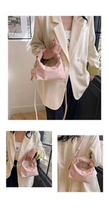 Detail of pink crossbody bag featuring a knotted handle and a round metal fashion tag