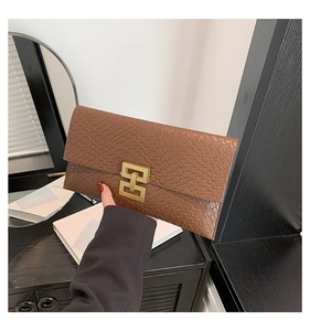 Detail view of brown animal texture envelope clutch with elegant gold geometric buckle