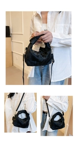 Detail view of black ruched handbag showing knot handle and adjustable crossbody strap