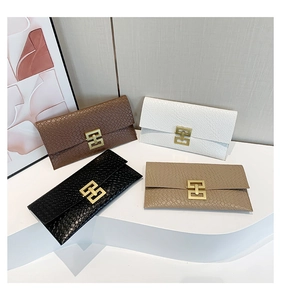 Detail of rhombic textured envelope clutch bag with elegant golden metallic clasp