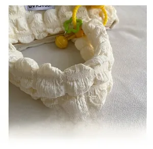 Detalle del bolso tote plisado blanco con cadena amarilla y colgante de estrella