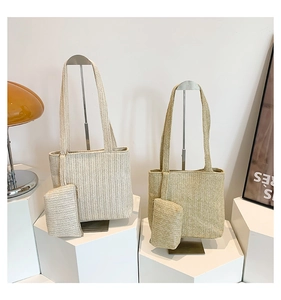 Détail d'un grand sac cabas en paille tissée avec pochette assortie et texture en chevrons