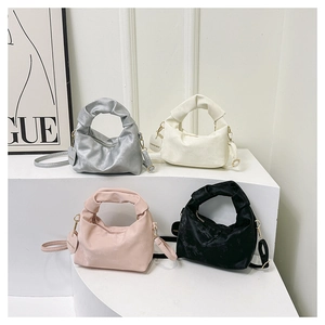 Detail of ruched handle handbags in silver pink black and white with logo tags