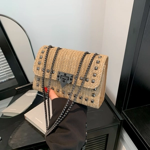 Sac bandoulière en paille tressée beige avec rivets noirs et bandoulière en chaîne