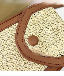 Detailed close-up of woven straw texture with brown leather edging and circular button