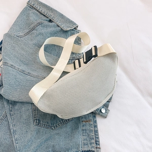 Detail of white mesh chest bag with nylon strap and buckle over denim jacket background