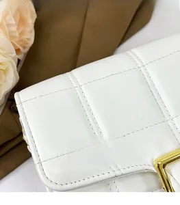 Detailed macro view of white quilted leather texture with premium golden metal clasp