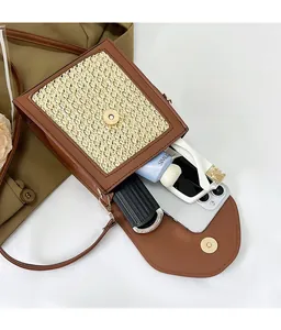 Detailed interior view showing space for phone and accessories in brown woven crossbody bag