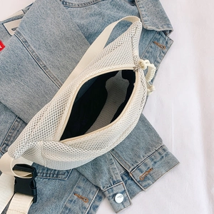Detail view of white mesh chest bag with double-layer grid design on denim jacket