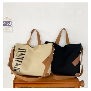 Vue détaillée de grands sacs cabas en toile avec lettrage JINNIAN et anses tressées