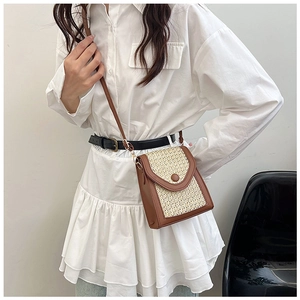 Detail view of mini crossbody bag with woven fabric and brown faux leather patchwork
