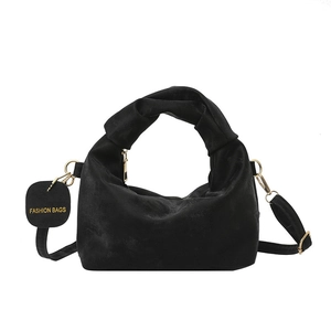 Black velvet ruched handbag with twisted handles and gold hardware on white background