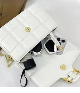 Internal view of white quilted chain bag showing space for phone, umbrella and sunglasses