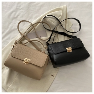 Detailed view of crocodile pattern leather handbags with golden square metal buckles