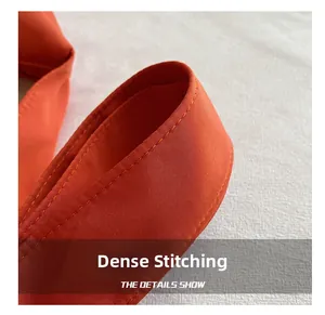 Close-up of orange crossbody bag with tight stitching and premium twill fabric texture