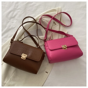 Detail view of coffee and pink square bags showing croc-embossed texture and gold clasps