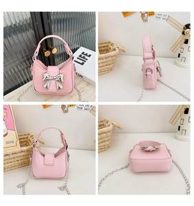 Detail view of pink mini handbag showing metal bow, chain strap and stitching quality