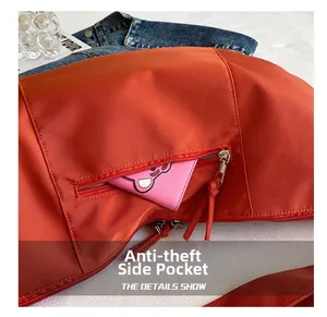 Close-up of burnt orange nylon bag featuring a secure anti-theft side zipper pocket