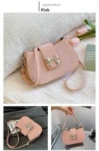 Nahaufnahme der rosa quadratischen Handtasche mit Faltenoptik und silberner Schleife