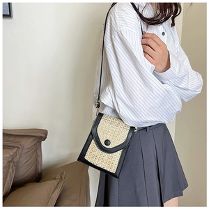 Detail view of woven mini crossbody phone bag with leather trim on model
