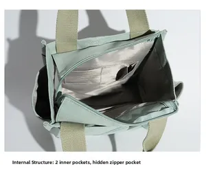 Detailed interior view of green canvas tote with two inner pockets and zipper closure