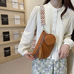 Detail of caramel crescent crossbody bag with ethnic patterned strap and round coin purse