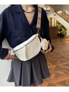 White crescent crossbody bag with lychee leather texture and geometric shoulder strap