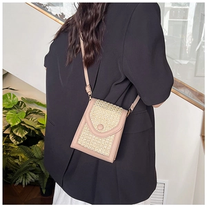Detail of crossbody phone bag showing woven gold texture and soft pink leather trim