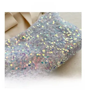 Gros plan détaillé de paillettes irisées sur tissu bleu clair et violet