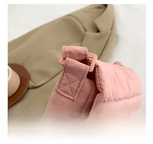 Detalle del bolso bandolera rosa acolchado mostrando la textura de la tela y la correa