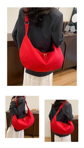 Detailed view of red canvas half-moon crossbody bag with adjustable wide strap on model