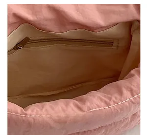 Primer plano del interior del bolso rosa con un bolsillo oculto con cremallera