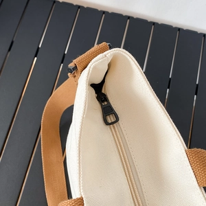 Détail de la fermeture éclair sécurisée et du tissu en toile du sac fourre-tout