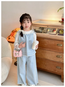 Detailed view of the light blue denim two-piece set for girls with bow tie and lace collar