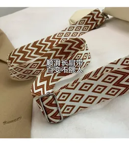 Close-up of adjustable woven shoulder strap with brown geometric patterns and silver buckles